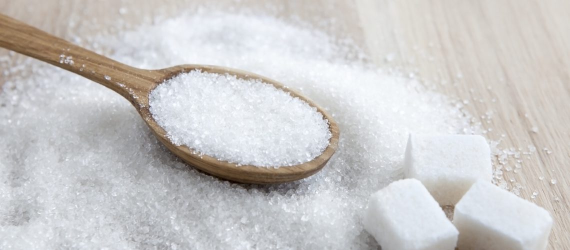 Cubes of sugar with wooden spoon