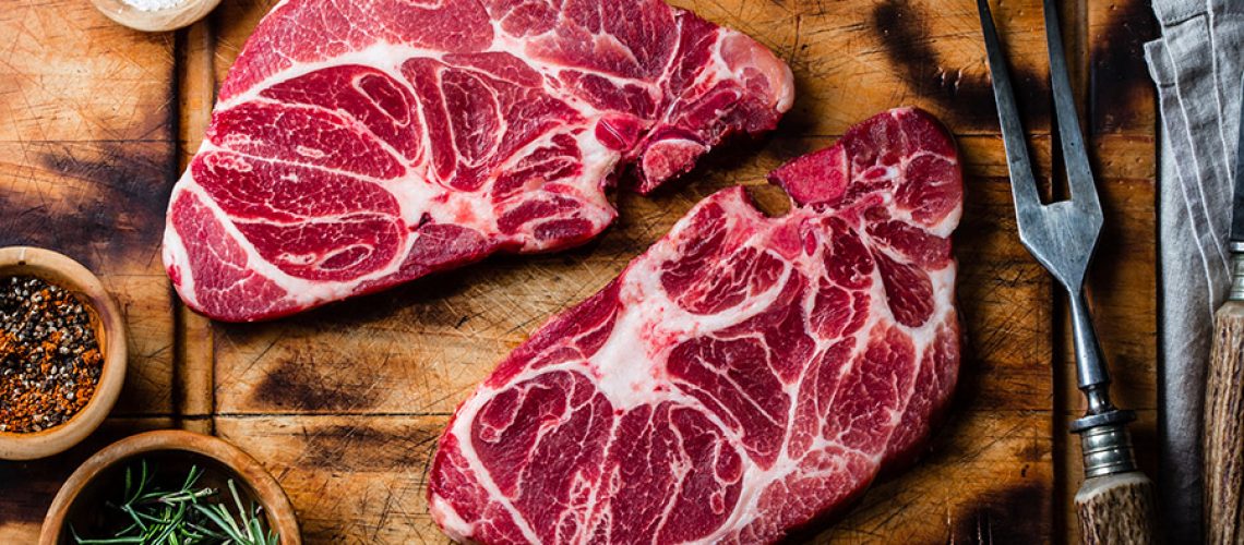 Raw marbled beef steaks on wooden cutting board. Top view