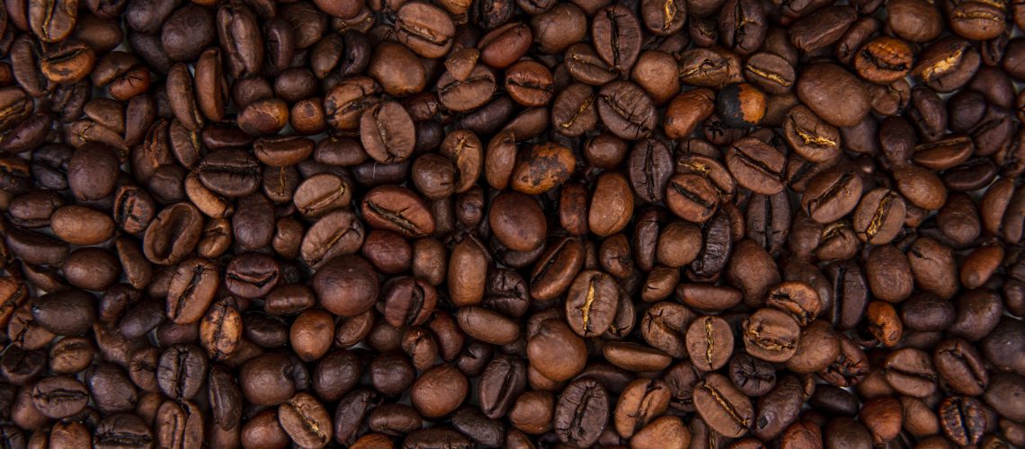 close up view of dark fresh roasted coffee beans on coffee beans background